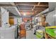View of the unfinished basement with exposed ceiling, concrete floor, and stored items at 1061 N Layman Ave, Indianapolis, IN 46219