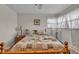 Comfortable bedroom with a large window, hardwood floors, and a cozy bed with patterned quilt at 1061 N Layman Ave, Indianapolis, IN 46219