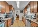 Galley kitchen featuring stainless steel appliances, wood cabinets, and wood floor at 1061 N Layman Ave, Indianapolis, IN 46219
