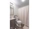 Cozy bathroom featuring a toilet, vanity with sink, mirror, and a shower with a patterned curtain at 10614 W Hickory Ct, Quincy, IN 47456