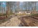 Single-story house featuring a front porch, gravel driveway, and mature trees at 10614 W Hickory Ct, Quincy, IN 47456
