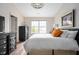 Serene bedroom featuring dark wood furniture, a large window, and a comfortable bed at 10799 Belair Dr, Carmel, IN 46280