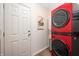 Modern laundry room featuring a vibrant red stacked washer and dryer set, adding a pop of color to the space at 10799 Belair Dr, Carmel, IN 46280