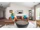 Comfortable living room featuring a plush couch, a unique center table, and ample natural light at 10799 Belair Dr, Carmel, IN 46280