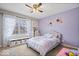 Charming bedroom with purple walls, decorative flowers, and ample natural light at 10889 Weston Dr, Carmel, IN 46032