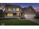 Charming two-story brick home with a covered porch, well-manicured lawn, and a two-car garage, perfect for Gathering living at 10889 Weston Dr, Carmel, IN 46032