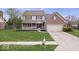 Beautiful two-story home with a brick facade, attached garage and well manicured lawn at 10889 Weston Dr, Carmel, IN 46032