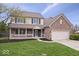Charming two-story brick home with a covered porch and well-manicured lawn at 10889 Weston Dr, Carmel, IN 46032