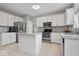 Modern kitchen featuring white cabinets, stainless steel appliances, granite countertops, and a convenient center island at 10889 Weston Dr, Carmel, IN 46032