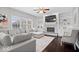 Bright living room with hardwood floors, a fireplace with built-ins, and large windows, creating a cozy atmosphere at 10889 Weston Dr, Carmel, IN 46032
