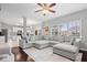 Open-concept living room with dark hardwood flooring, a large gray sectional couch, and plenty of room for entertaining at 10889 Weston Dr, Carmel, IN 46032
