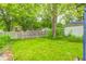 Large grassy backyard with a wooden fence and mature trees, offering privacy and shade at 11416 Stoeppelwerth Dr, Indianapolis, IN 46229