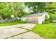 Spacious backyard featuring a weathered garage with basketball hoop, lush greenery, and ample space for outdoor activities at 11416 Stoeppelwerth Dr, Indianapolis, IN 46229