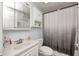 A well-lit bathroom featuring a vanity, mirror, toilet, and shower with a stylish gray and white curtain at 11416 Stoeppelwerth Dr, Indianapolis, IN 46229