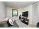 Functional bedroom features neutral walls, a cozy couch, and a TV on a stand, perfect for relaxation at 11416 Stoeppelwerth Dr, Indianapolis, IN 46229