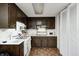 Classic kitchen featuring dark cabinetry, tile floor, and essential appliances at 11416 Stoeppelwerth Dr, Indianapolis, IN 46229