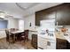 Functional kitchen with dark cabinets, essential appliances, dining area, and tile floors at 11416 Stoeppelwerth Dr, Indianapolis, IN 46229
