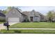 Beautifully landscaped front yard with a well-maintained lawn and charming light brick home at 11930 Pebblepointe Pass, Carmel, IN 46033