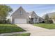 Lovely light brick house featuring a two-car garage and a well-manicured lawn on a sunny day at 11930 Pebblepointe Pass, Carmel, IN 46033