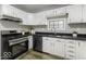 Modern kitchen with stainless steel appliances, white cabinets, and dark countertops at 126 S 3Rd Ave, Beech Grove, IN 46107