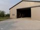 A view of the barn with a gray gravel floor and a large sliding door that's partially open at 13151 Walters Rd, Martinsville, IN 46151