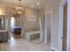 Elegant bathroom with a soaking tub, neutral tile and chandelier lighting at 13151 Walters Rd, Martinsville, IN 46151