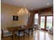 Elegant dining room with a crystal chandelier, wood flooring, and views of the property through large windows at 13151 Walters Rd, Martinsville, IN 46151