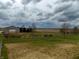 Lovely rural acreage featuring well-kept pastures, a barn, and mature trees under a dramatic sky at 13151 Walters Rd, Martinsville, IN 46151