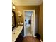 Bathroom view through doorway, showing dark vanity with white sink and neutral walls at 13993 Whittier Dr, Fishers, IN 46038