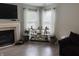 Relaxing living room with fireplace, large windows with white curtains, and modern shelving at 13993 Whittier Dr, Fishers, IN 46038