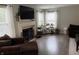Well-lit living room featuring a fireplace, hardwood floors, and large windows at 13993 Whittier Dr, Fishers, IN 46038