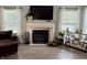Comfortable living room with fireplace, large windows, and a modern display shelf at 13993 Whittier Dr, Fishers, IN 46038