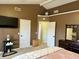 Bright main bedroom boasts a mounted television, neutral carpet, and an en-suite bathroom at 13993 Whittier Dr, Fishers, IN 46038