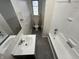 Well lit bathroom features a vanity, mirror, toilet, tiled walls, and a shower-tub combination at 1509 N Mann Ave, Muncie, IN 47304