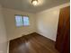 A bright bedroom is naturally lit by a window, complimented by wooden floors and a door at 1509 N Mann Ave, Muncie, IN 47304
