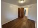 A clean bedroom is naturally lit by a window, complimented by wooden floors and a dark stained wood door at 1509 N Mann Ave, Muncie, IN 47304