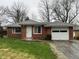 Charming brick home featuring a one-car garage and a well-maintained front lawn at 1509 N Mann Ave, Muncie, IN 47304