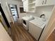 Bright laundry room features a white washer and dryer, wood flooring, and white cabinets for ample storage at 1509 N Mann Ave, Muncie, IN 47304