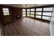 Sunroom with brick accent wall, large windows, and hardwood flooring at 1509 N Mann Ave, Muncie, IN 47304