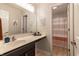 Bright bathroom with a sink, large mirror, and an adjacent shower with an orange and white curtain at 15493 Kennewick, Noblesville, IN 46062