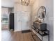 Inviting entryway with wood flooring and stylish decor, including a mirror and unique storage piece at 15493 Kennewick, Noblesville, IN 46062