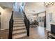 Bright foyer with staircase leading to dining area, with a traditional chandelier over a wooden dining table and hardwood floors at 15493 Kennewick, Noblesville, IN 46062