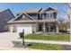 Charming two-story home with a well-manicured lawn, brick accents, and a three car garage at 15493 Kennewick, Noblesville, IN 46062