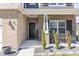 Inviting front porch with brick accents, decorative plants, and comfortable seating, perfect for relaxing outdoors at 15493 Kennewick, Noblesville, IN 46062