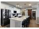 Modern kitchen featuring stainless steel appliances, white cabinets, a large island with seating and a sliding barn door pantry at 15493 Kennewick, Noblesville, IN 46062