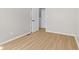 A neutral bedroom with two white doors and light wood colored floors at 1836 N Riley Ave, Indianapolis, IN 46218