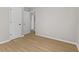 A neutral bedroom with two white doors and light wood colored floors at 1836 N Riley Ave, Indianapolis, IN 46218