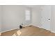 A minimalist bedroom featuring light wood floors and a window, with essential connections at 1836 N Riley Ave, Indianapolis, IN 46218