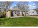 This home features light green siding, a concrete porch, healthy green lawn and a gravel drive on the side at 1836 N Riley Ave, Indianapolis, IN 46218