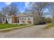 This home has light green siding, a well-kept lawn and gravel driveway with trees surrounding the property at 1836 N Riley Ave, Indianapolis, IN 46218